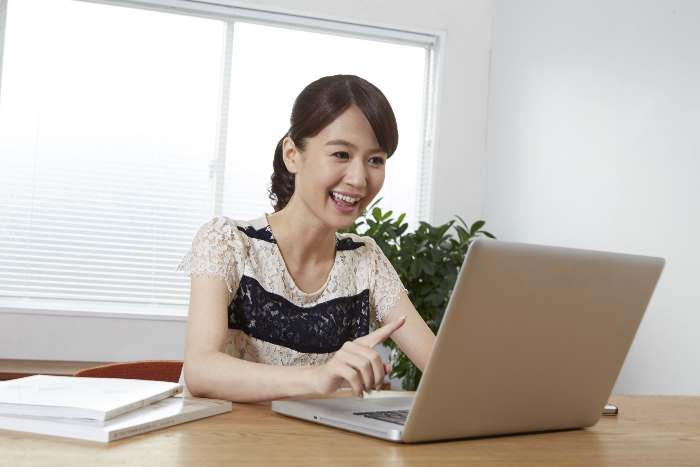 パソコンを使う笑顔の女性
