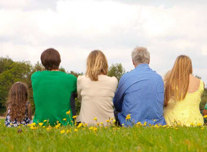 芝生の上に座る家族5人