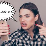 スマートフォンに向かって怒っている女性