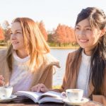 水辺でお茶を飲む女性二人