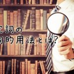 本棚の前で虫眼鏡を持つ男性