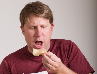 ポテトチップスを食べる男性