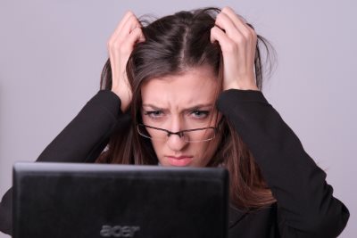 パソコンを見て悩む女性
