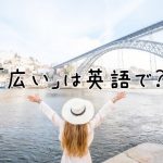 川の前で両手を広げる女性