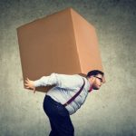 大きな箱を運ぶ太った男性