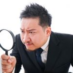 虫眼鏡を持つ会社員