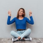座って上を指さす黒人女性