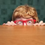 怖がって隠れる少年