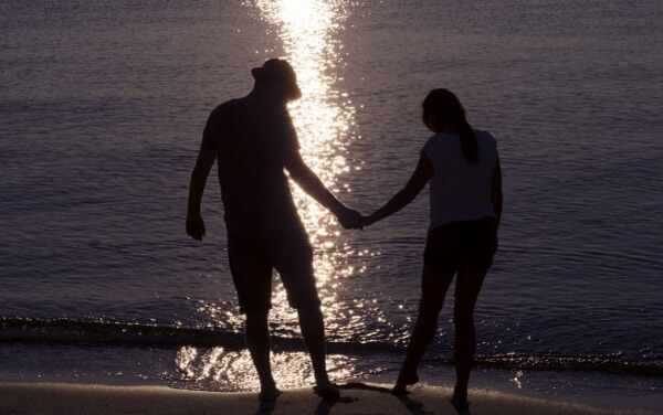 海岸で手をつなぐカップル