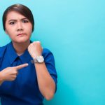 時計を指さすせっかちな女性