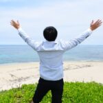 海岸でバンザイする男性