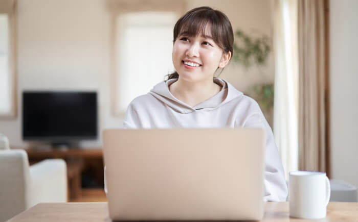 ノートパソコンを使う笑顔の女性